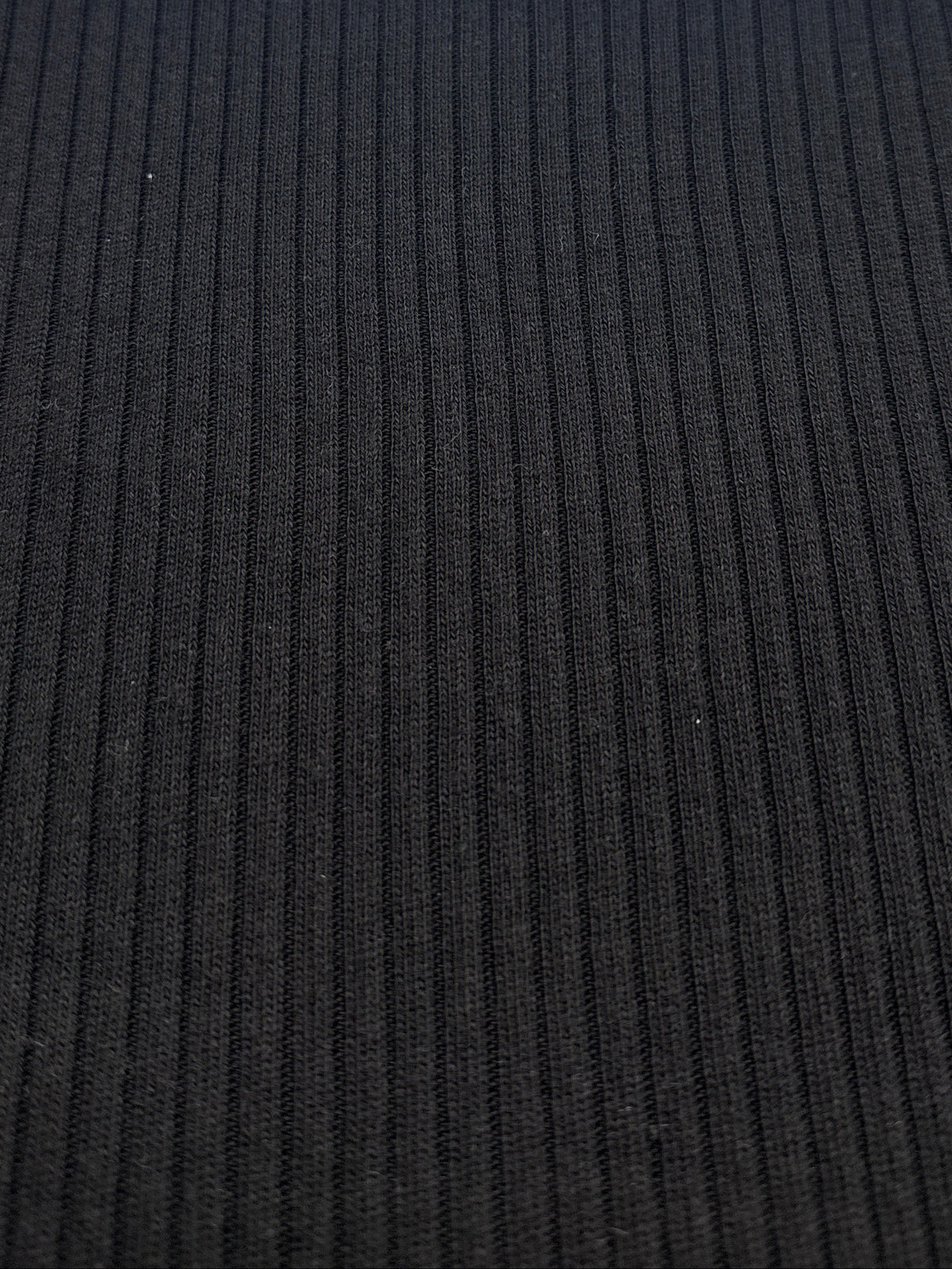 A close-up of a black ribbed knit fabric 