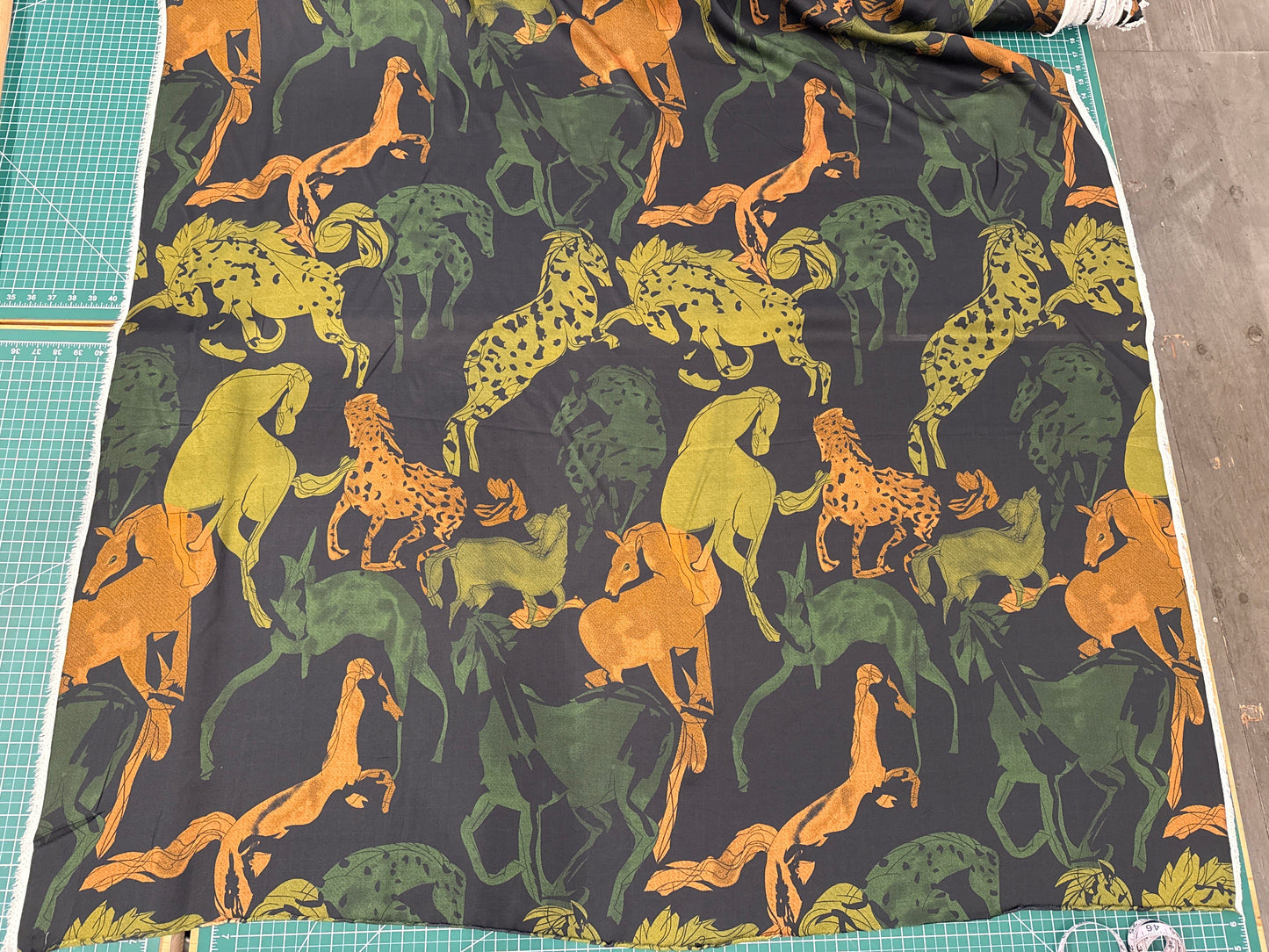 fabric with horses frolicking on a dark background