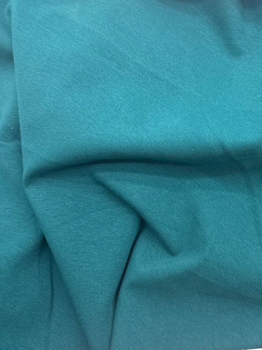 A close-up of teal fabric likely showing material color and texture.